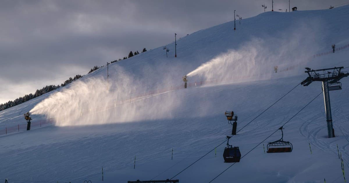 Snow cannons working on ski slope in Huez, France during winter.