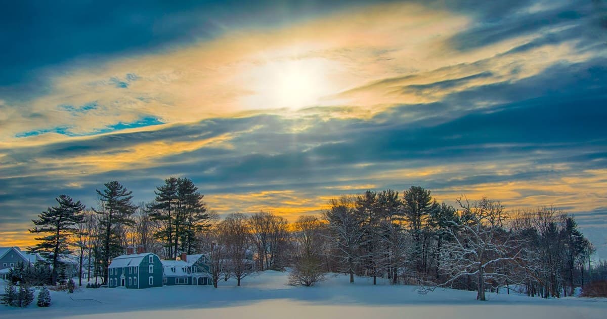 Serene winter morning with snow-covered landscape and beautiful sunrise in Southborough, MA.
